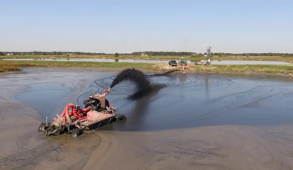 Lagoon crawler mixing material for removal